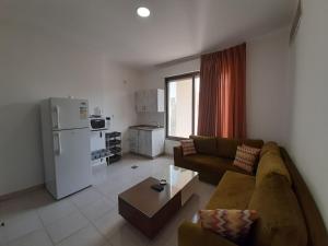 a living room with a couch and a refrigerator at Furnished Apartments Near McDonald's Al-Madina Al-Monawara St in Amman