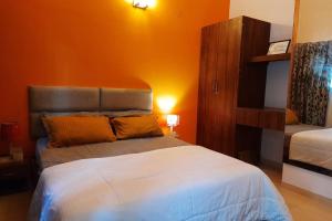 卡尔贾特Joy Cottages - Premium Chalets, Vacation Home Rentals的卧室里有一张床，墙壁是橙色的