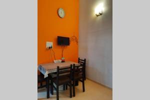卡尔贾特Joy Cottages - Premium Chalets, Vacation Home Rentals的用餐室配有桌椅和墙上的时钟 更多6张照片