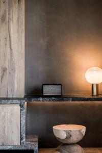 a table with a bowl and a lamp on it at Acro Suites - A Wellbeing Resort in Agia Pelagia