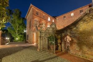 una entrada a un edificio de ladrillo con una puerta en Borgo San Lorenzo a Linari, en San Rocco a Pilli