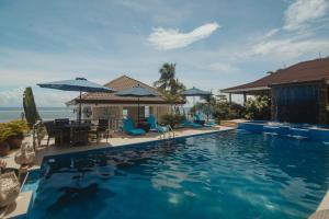 阿尔科伊Voda Krasna Resort & Restaurant的一个带椅子和桌子的游泳池以及一座房子