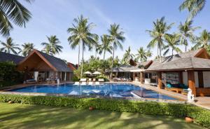 a swimming pool in front of a resort with palm trees at Baan Kilee in Lipa Noi