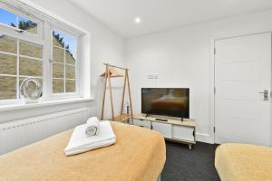 Et tv og/eller underholdning på Rochfords Serviced House with 5 Bedrooms, 4 bathrooms up to 12 beds By 360Stays