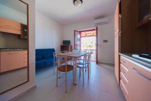 una cucina e una sala da pranzo con tavolo e sedie di Residence Devi a Mandatoriccio Marina Altre 50 foto
