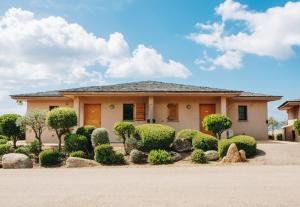 a house with bushes and trees in front of it at Résidence Les Terrasses de Rondinara in Bonifacio