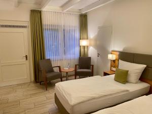 ein Hotelzimmer mit einem Bett, einem Tisch und Stühlen in der Unterkunft Waldhotel zum Bergsee Damme in Damme