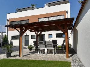 patio z krzesłami i drewnianą pergolą w obiekcie PENTHOUSE Griemann 1 mit Infrarotkabine und eigener Dachterrasse für max 4 Personen w mieście Illmitz