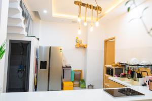 eine Küche mit einem Kühlschrank und einer Arbeitsplatte in der Unterkunft Mộc House Homestay in Đà Nẵng