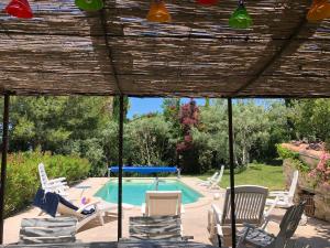 eine Terrasse mit Stühlen und einem Pool in der Unterkunft Provence aux Portes du Lubéron in Malemort-du-Comtat