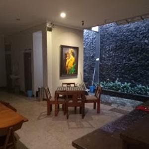 a living room with a table and chairs and a painting at Helena Guest House in Rampal