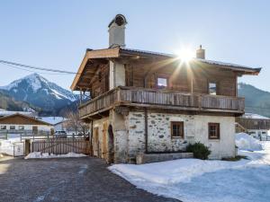 uma velha casa de madeira com o sol brilhando nela em Ferienhaus Auerbauer em Brixen im Thale