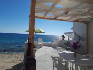 a patio with a table and chairs and the ocean at Villetta Frasena in Santa Maria