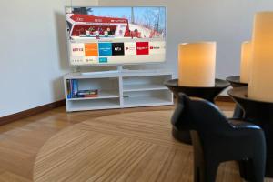 a living room with a flat screen tv on a white entertainment center at COZY Home with LAKE view-free WiFi - free SAUNA in Överkalix