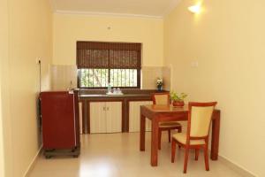 a kitchen with a table and chairs and a sink at Peter’s vacation rentals Goa in Calangute