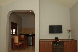 a living room with a tv and a table with chairs at Peter’s vacation rentals Goa in Calangute