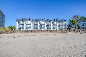 a building on the beach next to a sandy beach at Dock of the Bay 108 in Lincoln City