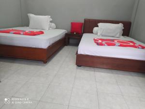 two beds sitting next to each other in a room at Omah Kost Family Syariah in Tulungagung