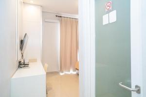 TV a/nebo společenská místnost v ubytování RedDoorz at Tirta Mansion Paramount Gading
