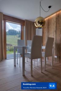 ein Esszimmer mit einem weißen Tisch und Stühlen in der Unterkunft Chalet Golf Campiglio / LuxApt / fronte piste-impianti-golf in Madonna di Campiglio