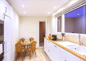 a kitchen with a table and chairs and a sink at Centre - L'Impérial - Parking in Saverne
