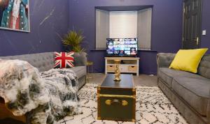 ein Wohnzimmer mit einem Sofa und einem TV in der Unterkunft 5 Bedroom House -Sleeps 12- Big Savings On Long Stays! in Canterbury