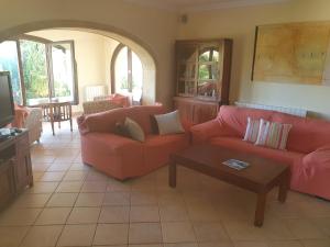 ein Wohnzimmer mit 2 Sofas und einem Couchtisch in der Unterkunft Fantastic villa with sea views pool and garden in Teulada