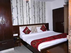 a bedroom with a large bed with red pillows at Hotel Flora Inn in Gurgaon