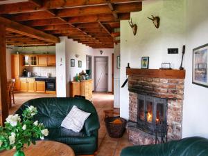 a living room with a couch and a brick fireplace at Landhaus am See von Robertville in Waimes