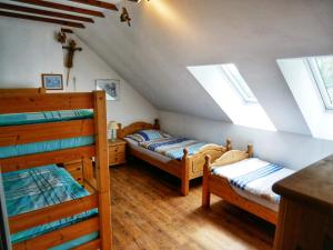 a attic bedroom with two bunk beds and windows at Landhaus am See von Robertville in Waimes