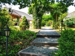 un chemin de jardin avec deux lumières et des arbres dans l'établissement Landhaus am See von Robertville, à Waimes