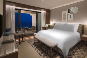 a bedroom with a large bed and a living room at Amara - Sea Your Only View&trade; in Limassol