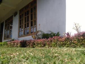 a house with a flower garden in front of it at AGP home in Nuwara Eliya