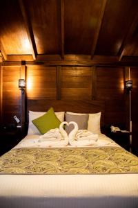 Una cama con dos toallas de cisne. en Sigiriya King's Resort en Sigiriya