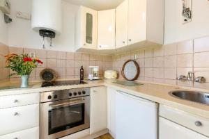 a kitchen with white cabinets and a sink at RügenHerz Fischerhütte in Parchtitz