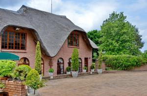 a large brick building with a black roof at Owls Loft Guest House in Midrand