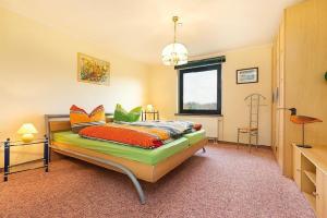 ein Schlafzimmer mit einem Bett mit bunten Kissen darauf in der Unterkunft RügenHerz Strandliebe in Parchtitz