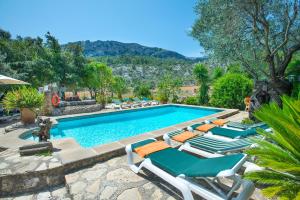 a swimming pool with chaise lounge chairs and a swimming pool at Owl Booking Villa Rafals - Wonder in the Midst of Nature in Pollença