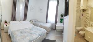 a bedroom with two beds and a bathroom with a sink at Modern Room with private bathroom in Trento