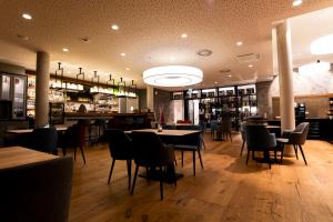 a restaurant with tables and chairs and a bar at Villa Prinzhorn in Diepholz