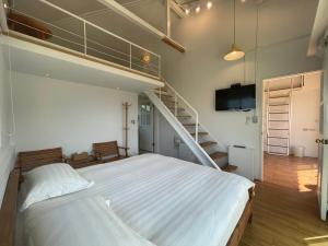 ein Schlafzimmer mit einem Etagenbett und einer Treppe in der Unterkunft Golden101 Bed and Breakfast in Jiufen