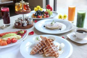 a table with plates of breakfast foods and a cup of coffee at The Lodhi – A member of The Leading Hotels Of The World in New Delhi