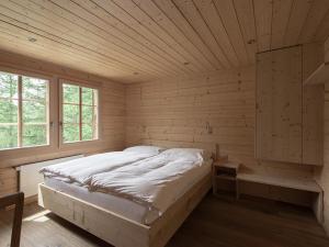 una camera da letto con un letto in una stanza di legno di Hotel Fafleralp a Blatten im Lötschental