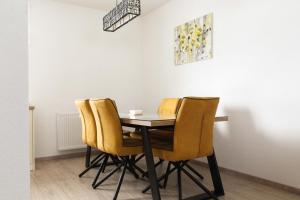a dining room with a table and yellow chairs at Kuća za odmor ANA in Kupres