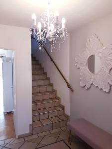 a staircase with a chandelier and a mirror on the wall at Casa Magnolia Vienna in Leopoldsdorf