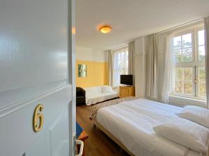 ein Schlafzimmer mit einem großen Bett und einem Fenster in der Unterkunft Landgoed Huize Glory in Bergen aan Zee