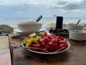 une assiette de fruits sur une table près de l'océan dans l'établissement Cherai Onetree Retreat, à Cherai Beach