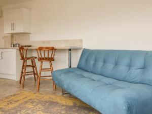 a blue couch in a kitchen with a table at The Stables in Taunton