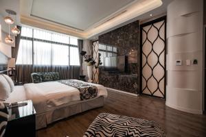 um quarto de hotel com uma cama e uma televisão em Blossom Motel em Puxin