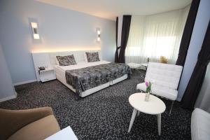 a bedroom with a bed and a couch and a table at Grand Nora Hotel in Ankara